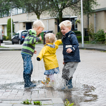 Kinderen spelen in een regenplas