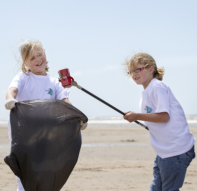 Twee meisjes hebben plezier terwijl ze samen blikjes opruimen op het strand