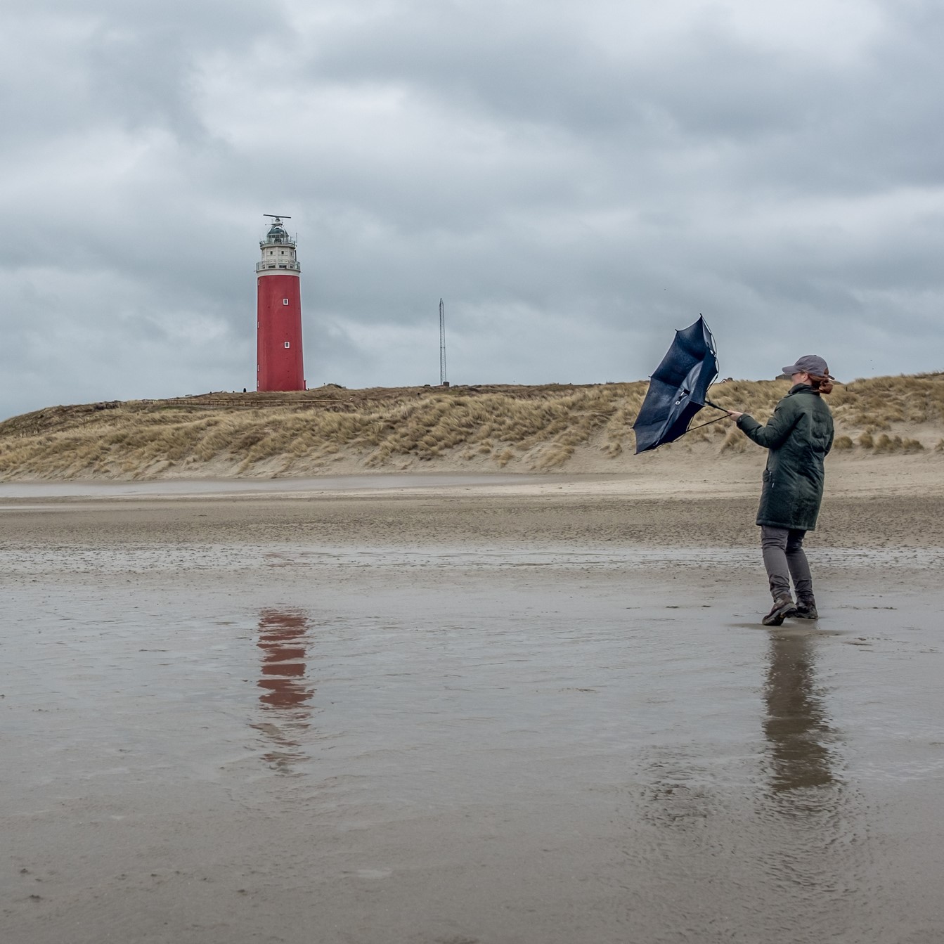 Vrouw met paraplu op een regenachtig strand
