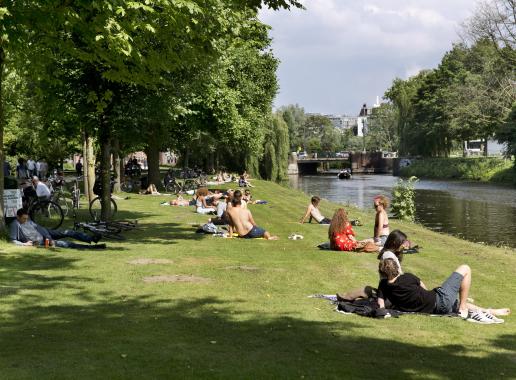 Mensen relaxen aan water in Utrechts stadspark 