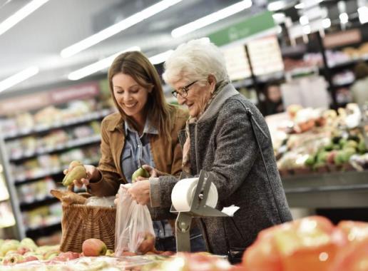 Foto van een oudere en een jongere dame die samen boodschappen doen