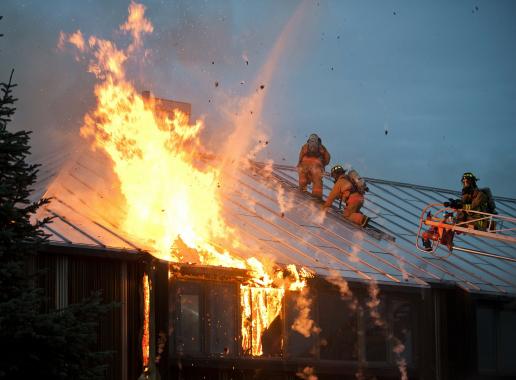 Vuur op dak met brandweerlieden