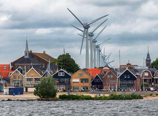 Een rij windturbines die vlakbij huizen staan