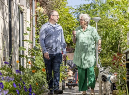 Man en vrouw wandelen met hond in groene stad