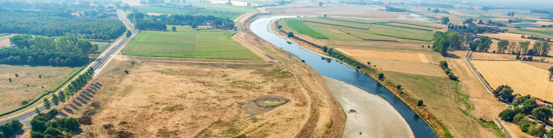 Luchtfoto van rivier met lage waterstand en droog land langs de oevers