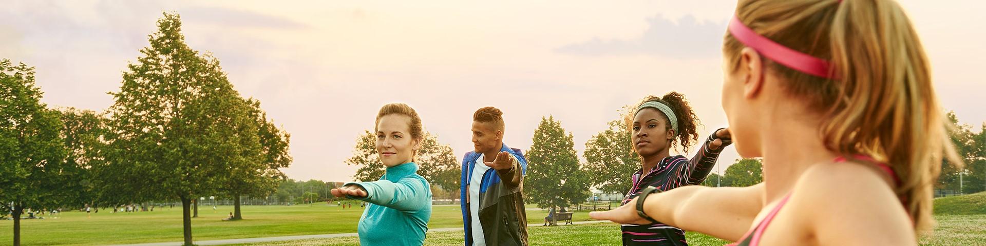 Vier mensen in sportkleding in het park