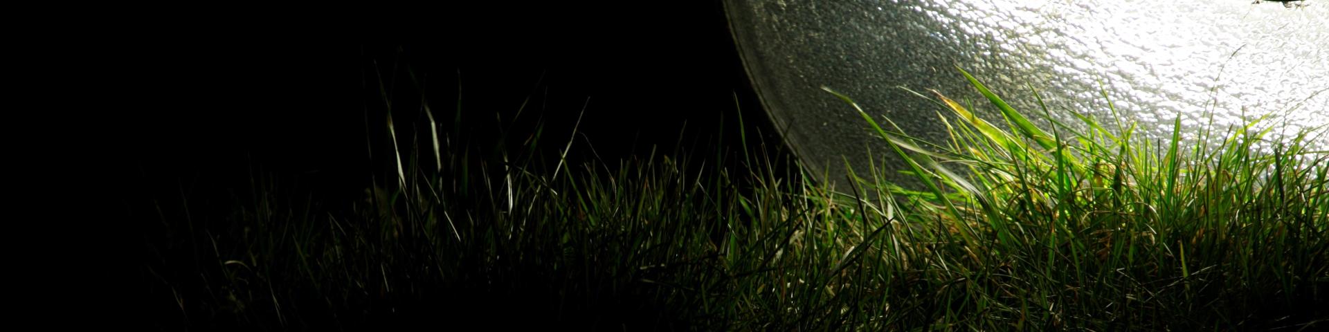 omgevallen lantarenpaal die licht op het gras schijnt