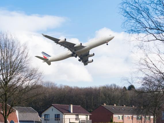 Vliegtuig vliegt laag over huizen