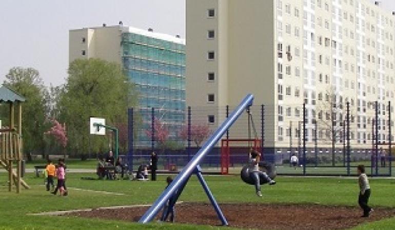 Flat met speeltuin Flat met op de voorgrond speeltuin met spelende kinderen