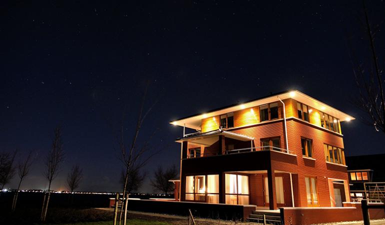 Lees over nachtelijk licht Een pand licht op in een donkere nacht