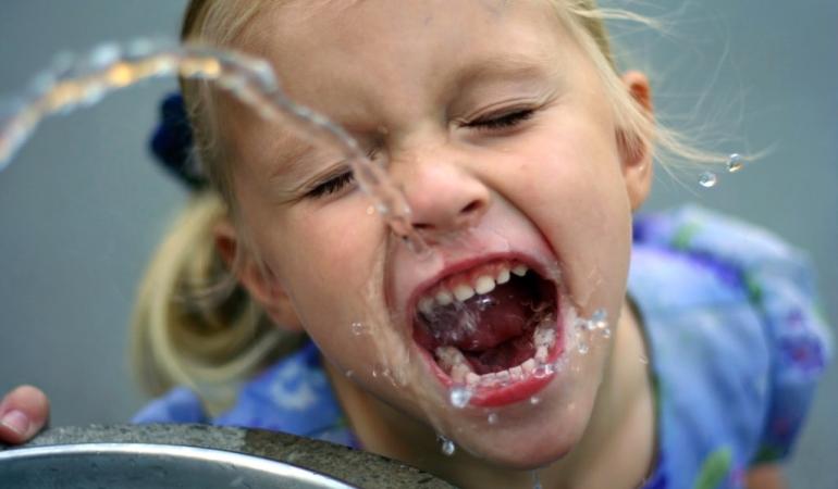 Kind drinkt water uit een fonteintje