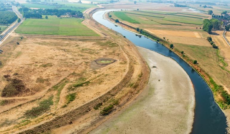 Luchtfoto van rivier met lage waterstand en droog land langs de oevers