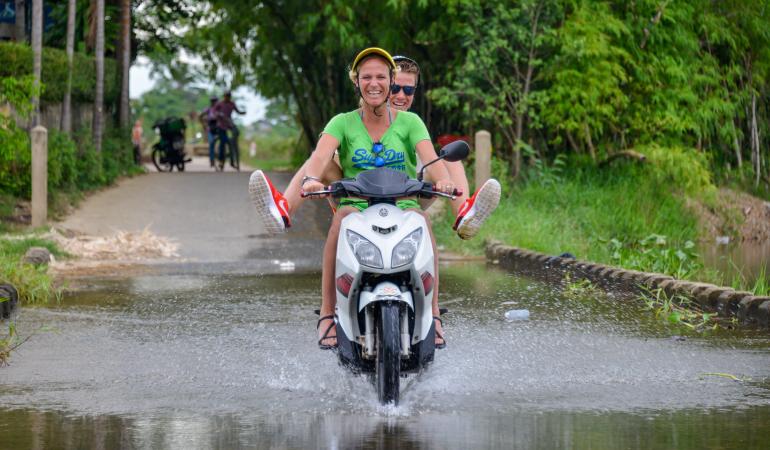 Wateroverlast scooter rijdt door plas