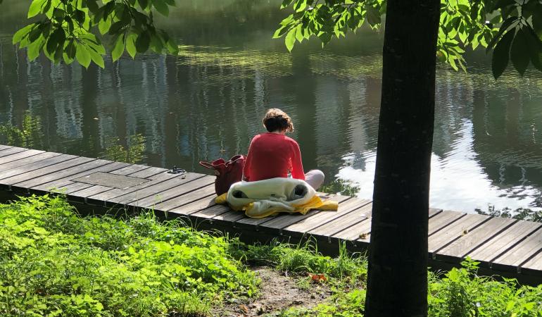 Vrouw zit op steiger aan Utrechtse Singel