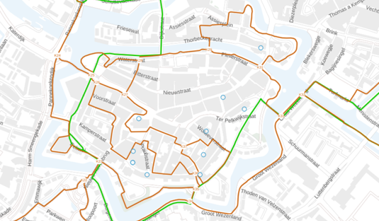Locaties van de monumententour omcirkeld op een plattegrond van Zwolle met wandel- en fietsroutes