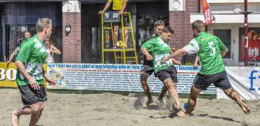 Beachvoetbal op strand, scheidsrechter kijkt toe