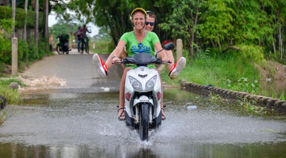Wateroverlast scooter rijdt door plas