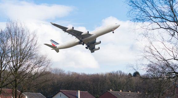 Vliegtuig vliegt laag over huizen