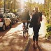 Fietsers, wandelaars en geparkeerde auto's in straat in Leiden in schemering