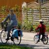 Moeder en kind op de fiets door een straat in een woonwijk