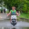 Wateroverlast scooter rijdt door plas