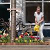 Vrouw geeft planten in geveltuin water in straat in Utrecht