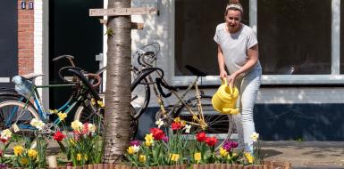 Vrouw geeft planten in geveltuin water in straat in Utrecht